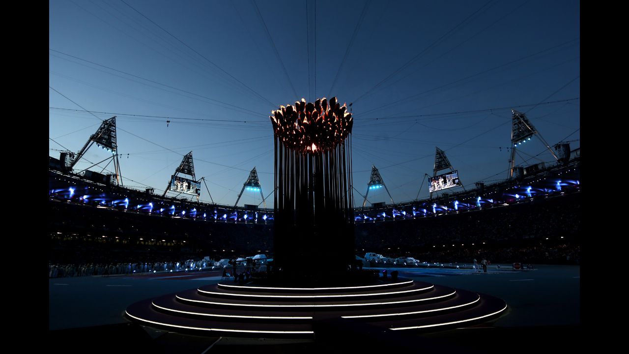 The Olympic Cauldron burns at the center of the stadium.