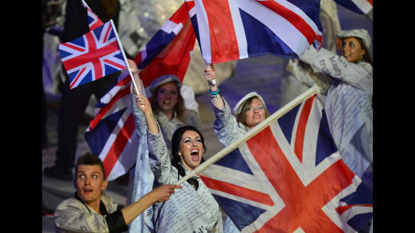 Artists wave Union Jack flags as they perform during the closing ceremony.