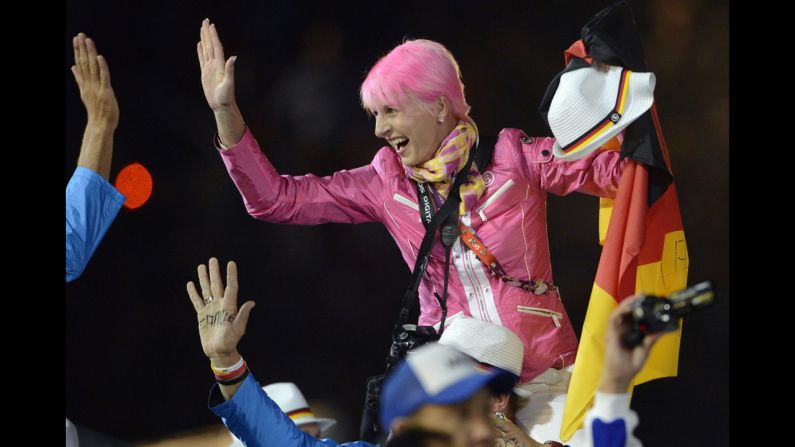 An athlete waves a German flag during the athletes' parade at the Olympic stadium.