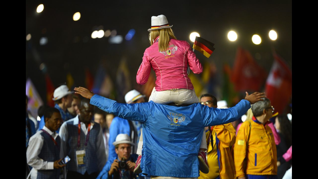A female athlete from Germany rides on the shoulders of a male teammate during the closing ceremony.