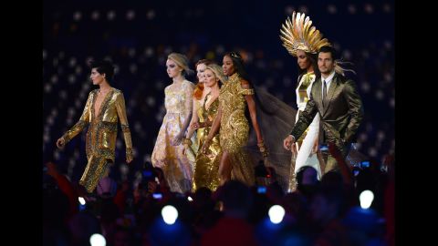 From left, British models Stella Tennant, Lily Cole, Karen Elson,  Kate Moss,  Naomi Campbell,  Jourdan Dunn and David Gandy perform at the Olympic stadium.
