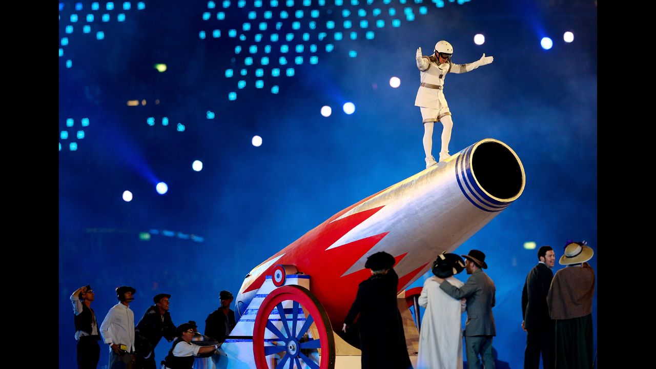  A performer stands on top of a giant cannon.