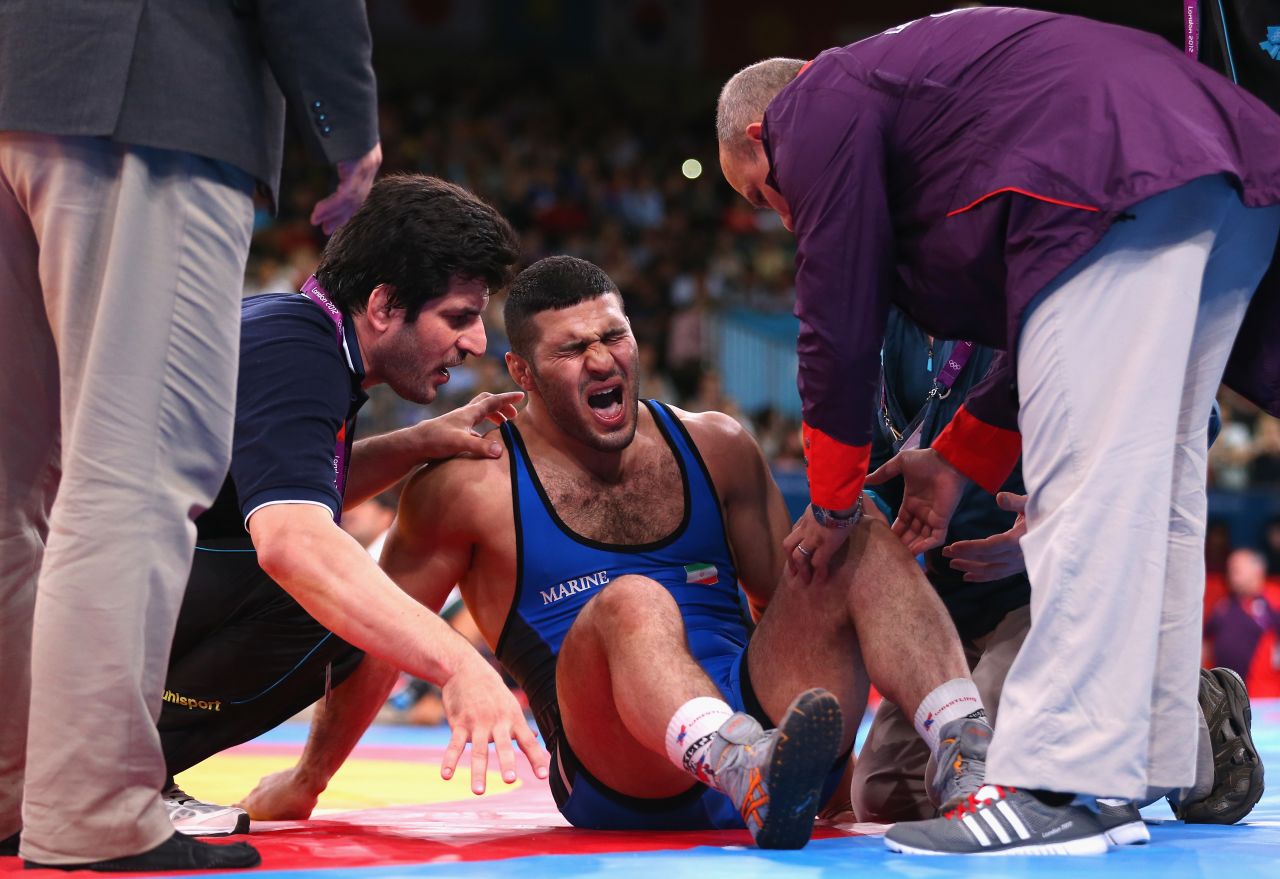 Reza Mohammad Ali Yazdani of Iran is treated for an injury during the men's freestyle wrestling 96-kilogram semifinal match.