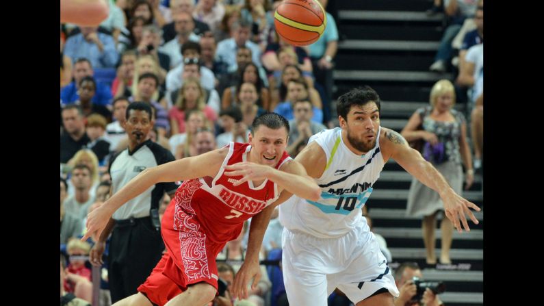 Argentine guard Carlos Delfino, right, challenges Russia's Vitaliy Fridzon for the ball during the men's bronze medal basketball game.