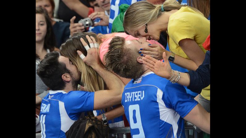 Italy's Michal Lasko, left, and Ivan Zaytsev seal their victory with a kiss from loved ones after defeating Bulgaria in the men's volleyball bronze medal match.