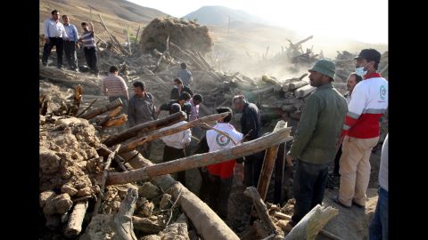 Iranian residents and rescue workers search for survivors in the rubble of a house in the village Baje-Baj.