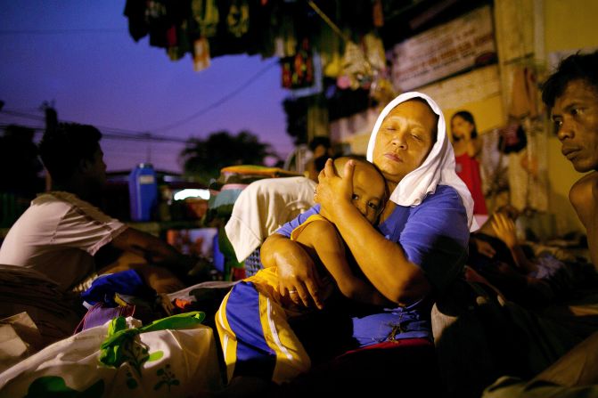 Lornitas Calub hugs her grandson at a crowded evacuation shelter in Manila on Monday.
