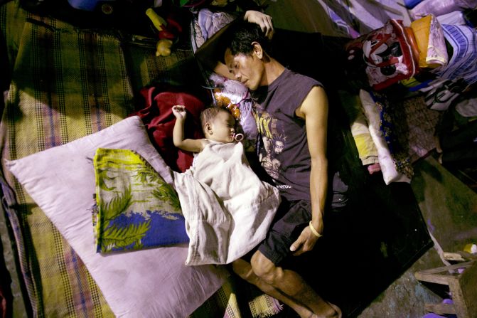Displaced flood victims sleep at a crowded evacuation shelter in Manila on Monday, August 13.