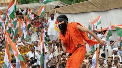 Indian yoga guru Baba Ramdev climbs on the roof of a car to address his followers in New Delhi on Tuesday.
