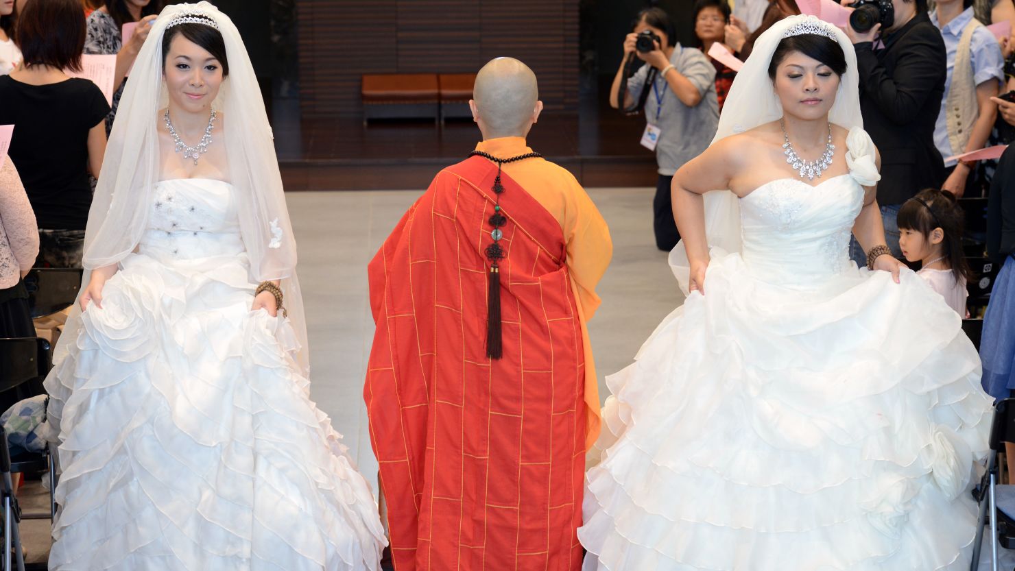 Huang Mei-yu (R) and her partner You Ya-ting attend their Buddhist wedding ceremony in Taoyuan, Taiwan, on Saturday.