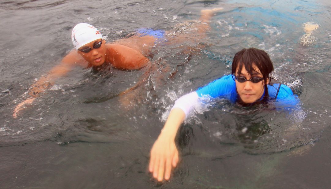 South Korean singer Kim Jang-Hoon (R) swims in the sea off Uljin, 225 kms southeast of Seoul, on August 13, 2012. He's among more than 40 swimmers who are part of a politically-charged relay team swimming from South Korea to the contested islands of Dokdo, or Takeshima as they're known in Japan.