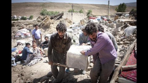 People remove belongings from collapsed buildings in Ahar in northwest Iran on Monday.