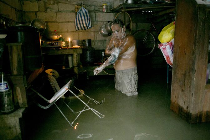 Antonio Navarro Sambiilay  bathes inside his flooded home in Bulacan, Philippines. 