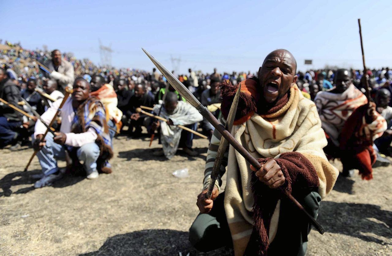 Striking South African miners armed with homemade spears and pangas chant slogans near the Marikana platinum mine on  August 16, 2012. Rising tensions at the mine exploded into grisly violence after police opened fire on striking miners.