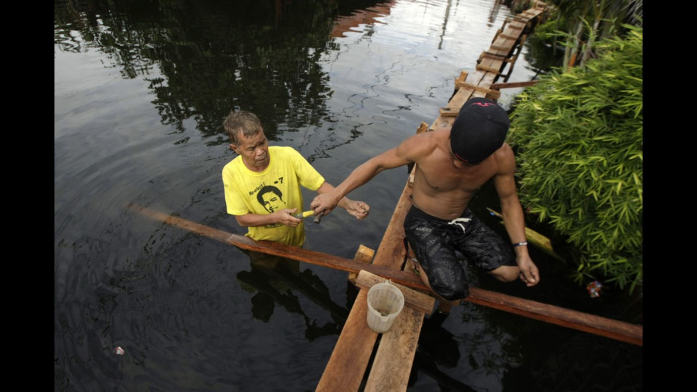 Filipino residents reinforce a footbridge on a flooded road. Last week's deluge was the worst to hit Manila and surrounding areas since 2009, when Tropical Storm Ketsana caused flash floods that left hundreds dead or missing.
