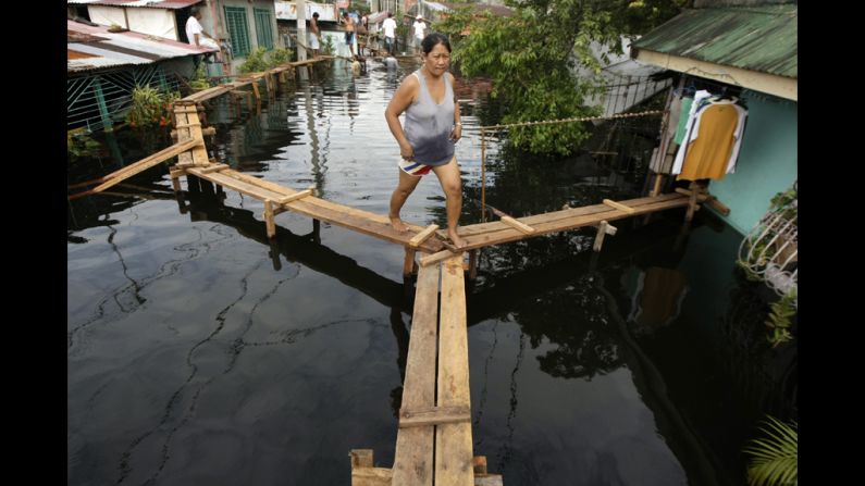 Filipino Nelia Lasona walks along a footbridge.