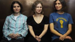 Members of the all-girl punk band 'Pussy Riot' Nadezhda Tolokonnikova (R), Maria Alyokhina (R) and Yekaterina Samutsevich (C) sit in a glass-walled cage during a court hearing in Moscow on Agust 17, 2012. A Moscow court will pass judgement Friday on three women from a tiny punk band who captured global attention by defying the Russian authorities and ridiculing President Vladimir Putin in a church. Pussy Riot release rallies have stretched from Sydney to New York as a growing list of celebrities joined ex-Beatle Paul McCartney and pop icon Madonna in a campaign directed against Putin's crackdown on most dissent. AFP PHOTO / ANDREY SMIRNOV (Photo credit should read ANDREY SMIRNOV/AFP/GettyImages) 