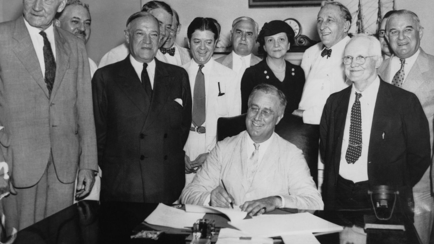 Franklin Roosevelt signs the 1935 Social Security Act into law. 