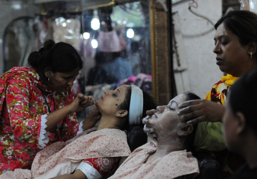 Pakistani beauticians attend to their customers ahead of the Muslim festivities of Eid al-Fitr, in Karachi.