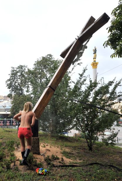 The court case has sparked demonstrations of support across Europe and the U.S. An activist from feminist group Femen cuts down an Orthodox cross in Ukraine, erected in memory of victims of political oppression, in a show of solidarity with the punk band.