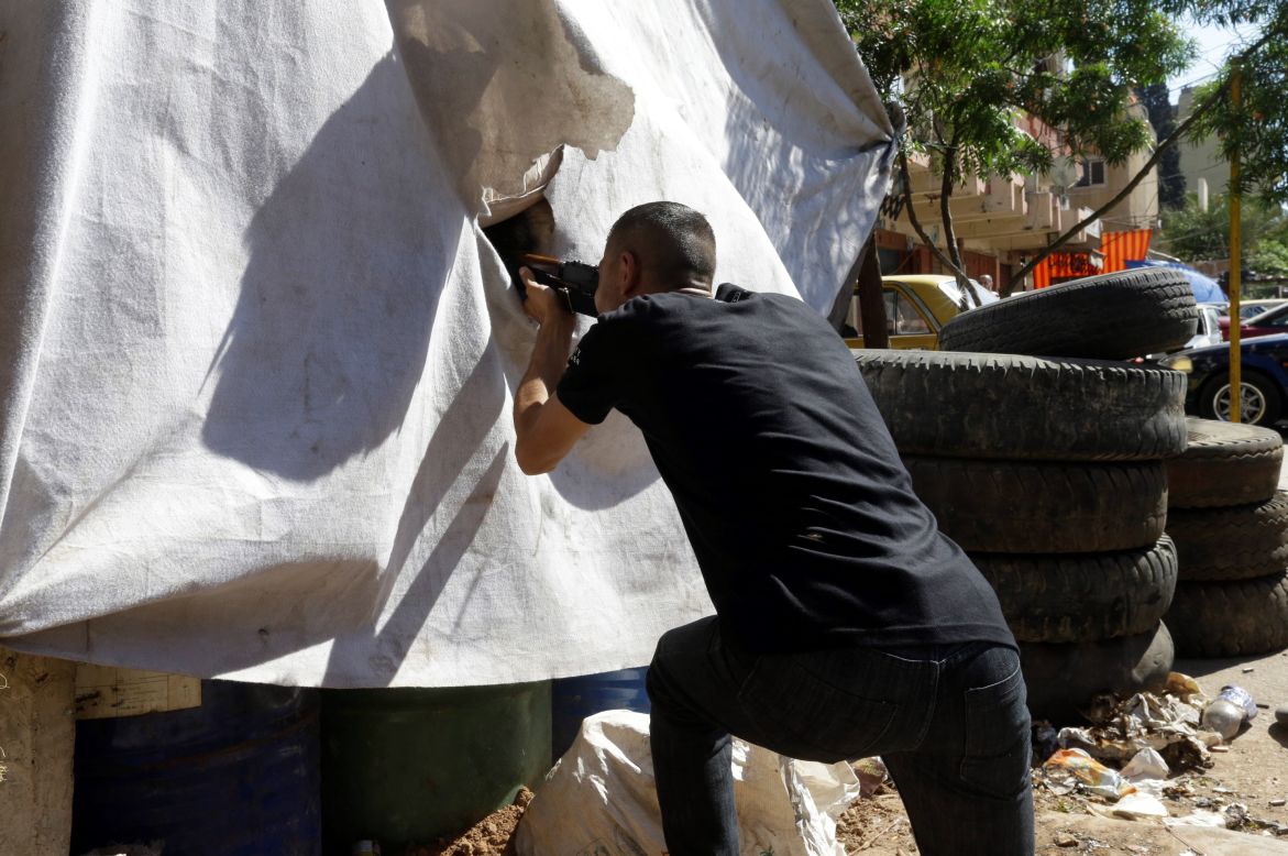 An opponent of the Syrian regime gets ready to fire during clashes Wednesday in Tripoli's Bab al Tabaneh neighborhood.