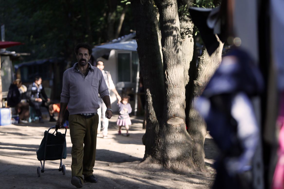 Fearing that he will be expelled, a man from the Roma community carries his personal belongings with him.