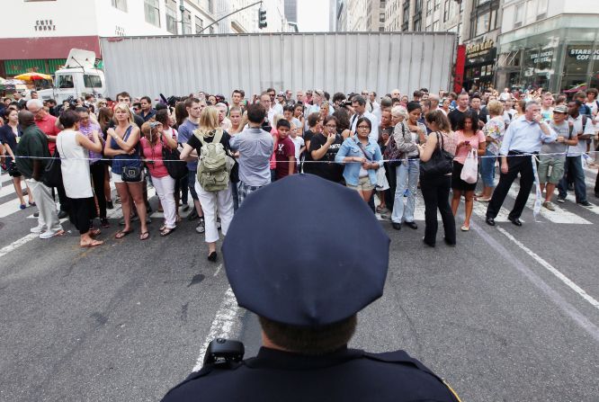  A New York police officer keeps watch near the crime scene Friday.  Authorities closed several streets around Fifth Avenue and West 34th Street, snarling traffic in the heart of Manhattan.