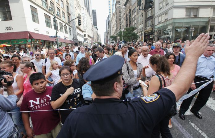 A New York police officer directs pedestrians near the crime scene Friday. The Empire State Building is one of New York's best-known tourist attractions.