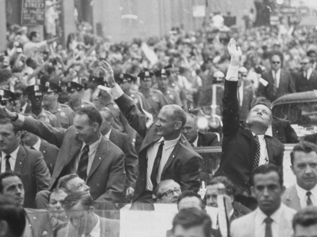 Apollo 11 astronauts Neil Armstrong, Buzz Aldrin and Michael Collins waving to crowds at a parade celebrating their return from the moon. 
