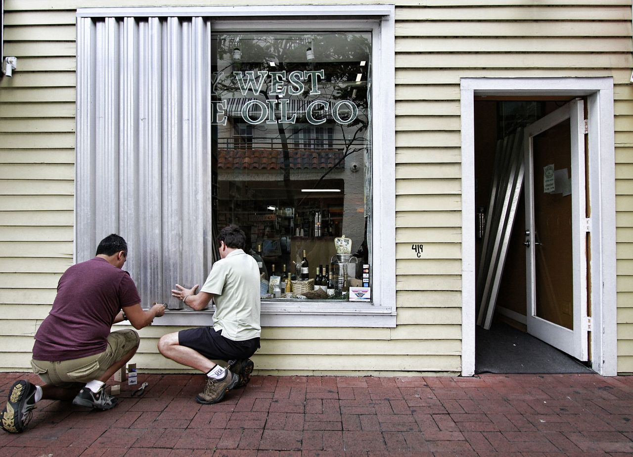 Two men install storm shutters on Duval Street on Saturday.