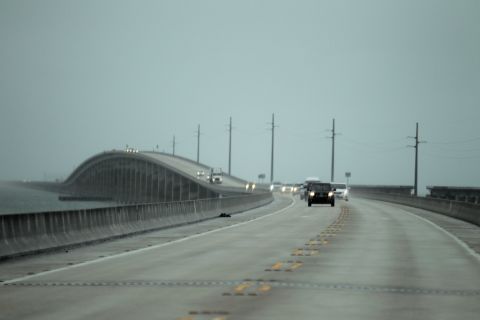 Vehicles cross a bridge leaving the Lower Keys on Saturday as the storm strengthens and moves closer.