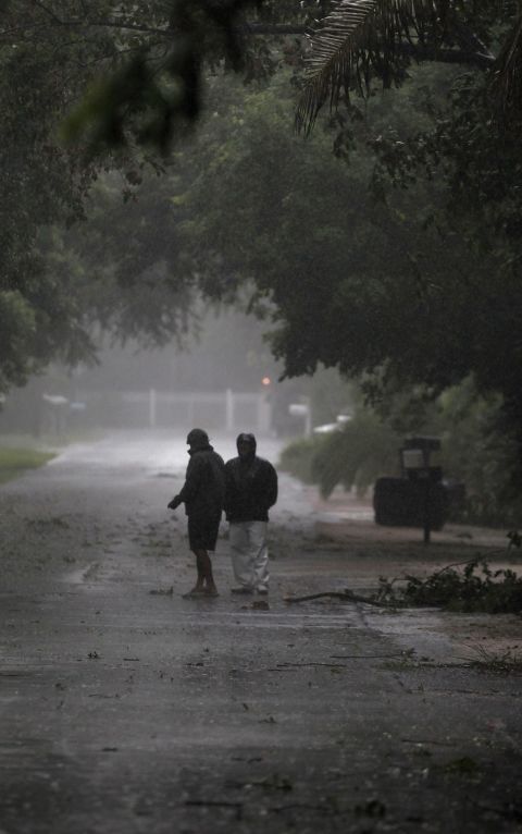 People venture out into the stormy weather as Tropical Storm Isaac passed by Marathon, Florida, on Sunday.