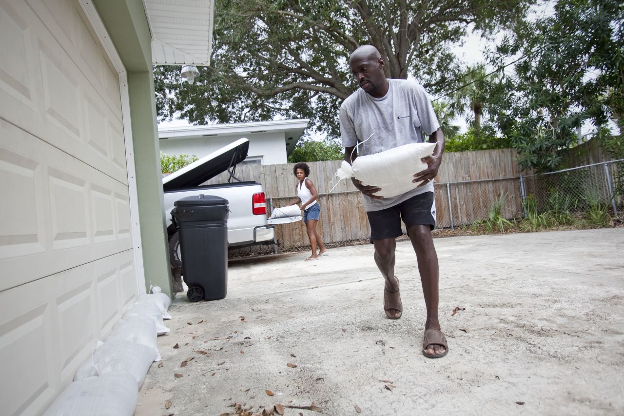 Earl, right, and Terri Harris place sandbags around their home to prepare for possible flooding.