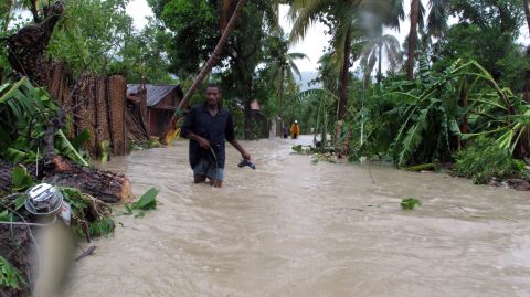 Residents of Jacmel, Haiti, make their way through floodwaters as Tropical Storm Isaac dumps heavy rains in August 2012. An extreme exposure to climate-related events, combined with poor health care access, weak infrastructure, high levels of poverty and an over-reliance on agriculture have led to the country being categorized as at "extreme" risk.