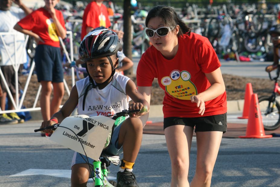 A volunteer gives Lincoln Fletcher a push to send him on his three-mile bike ride. 