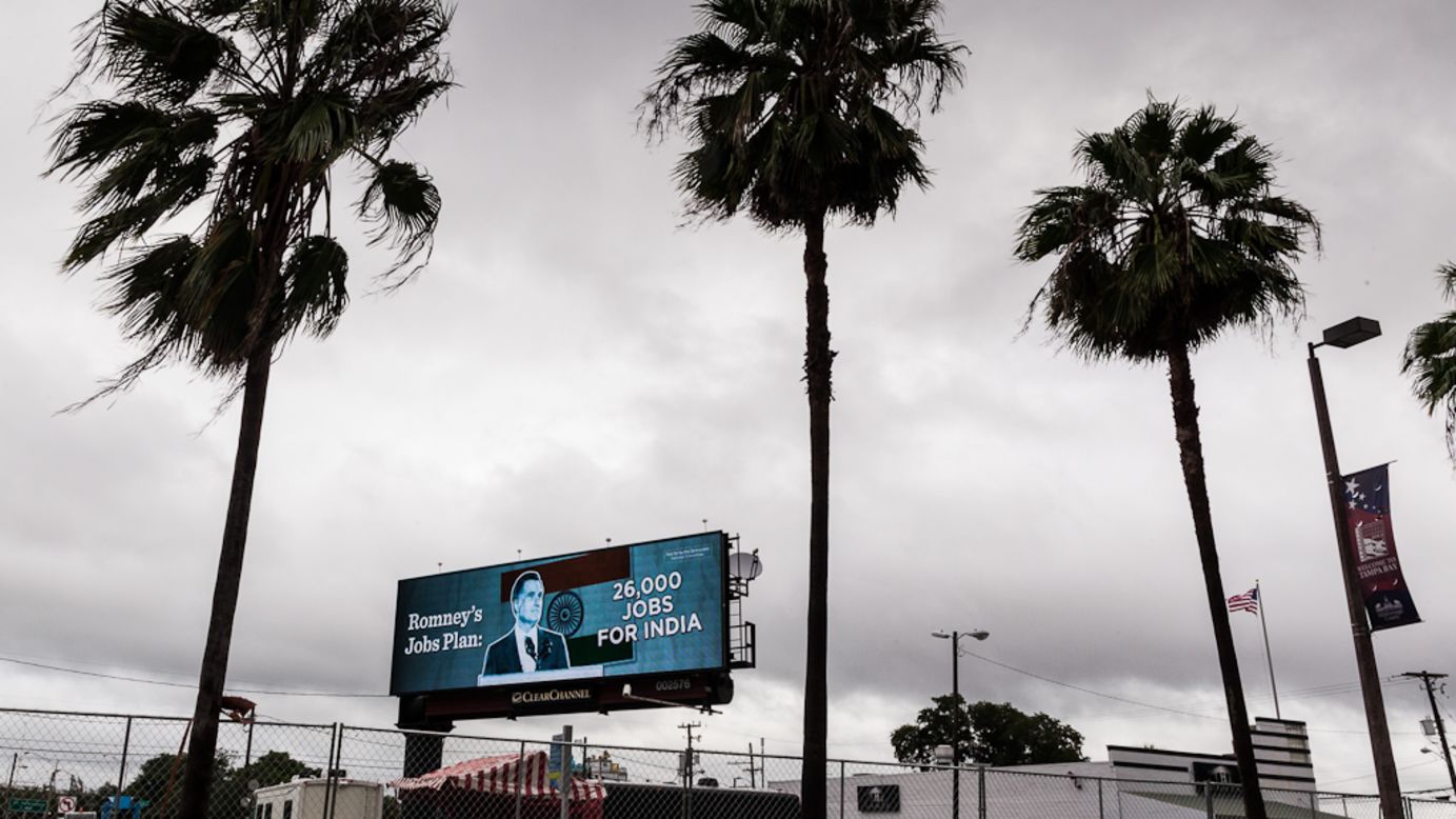 A billboard opposing Mitt Romney stands among palm trees Monday.
