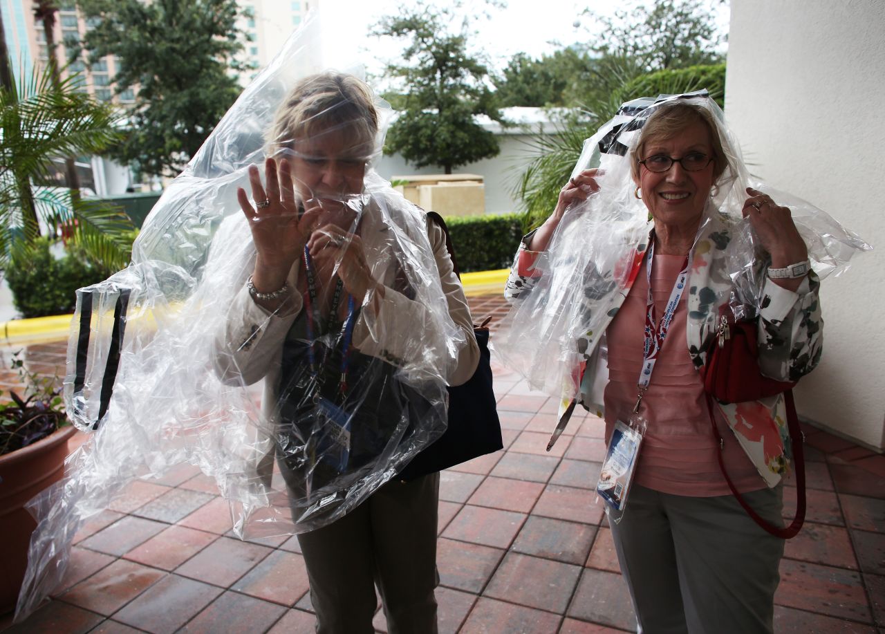 Two convention-goers wear plastic bags as shelter from the rain caused by Tropical Storm Isaac.