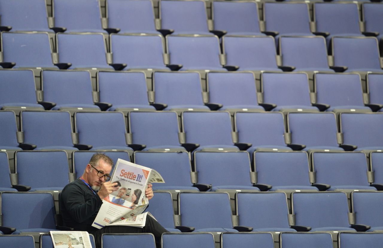 A man reads a newspaper in the empty seats of the Tampa Bay Times Forum.