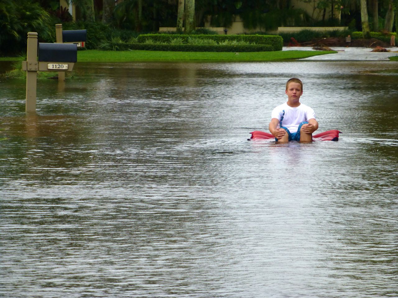 iReporter Liz Yavinsky snapped this picture of a boy floating down a flooded street in West Palm Beach, Florida, on Monday.