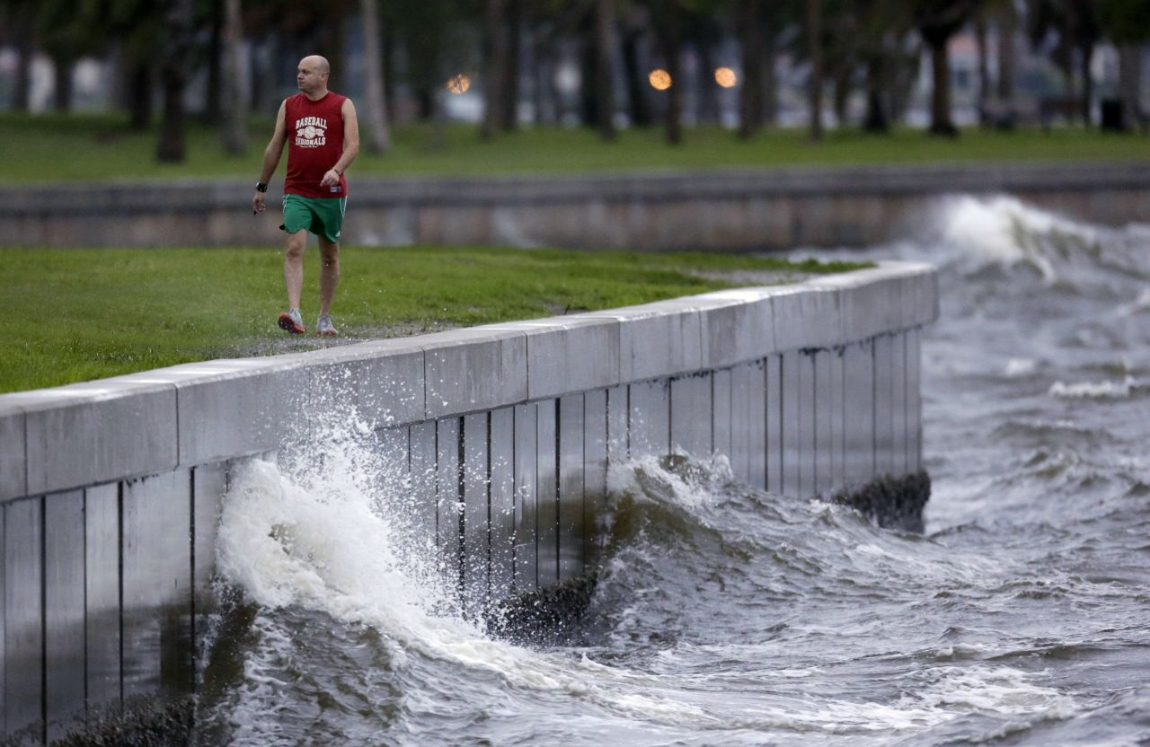 A St. Petersburg, Florida, resident walks along the sea wall at Spa Beach, where larger than average waves were being kicked up by Tropical Storm Isaac on Monday.