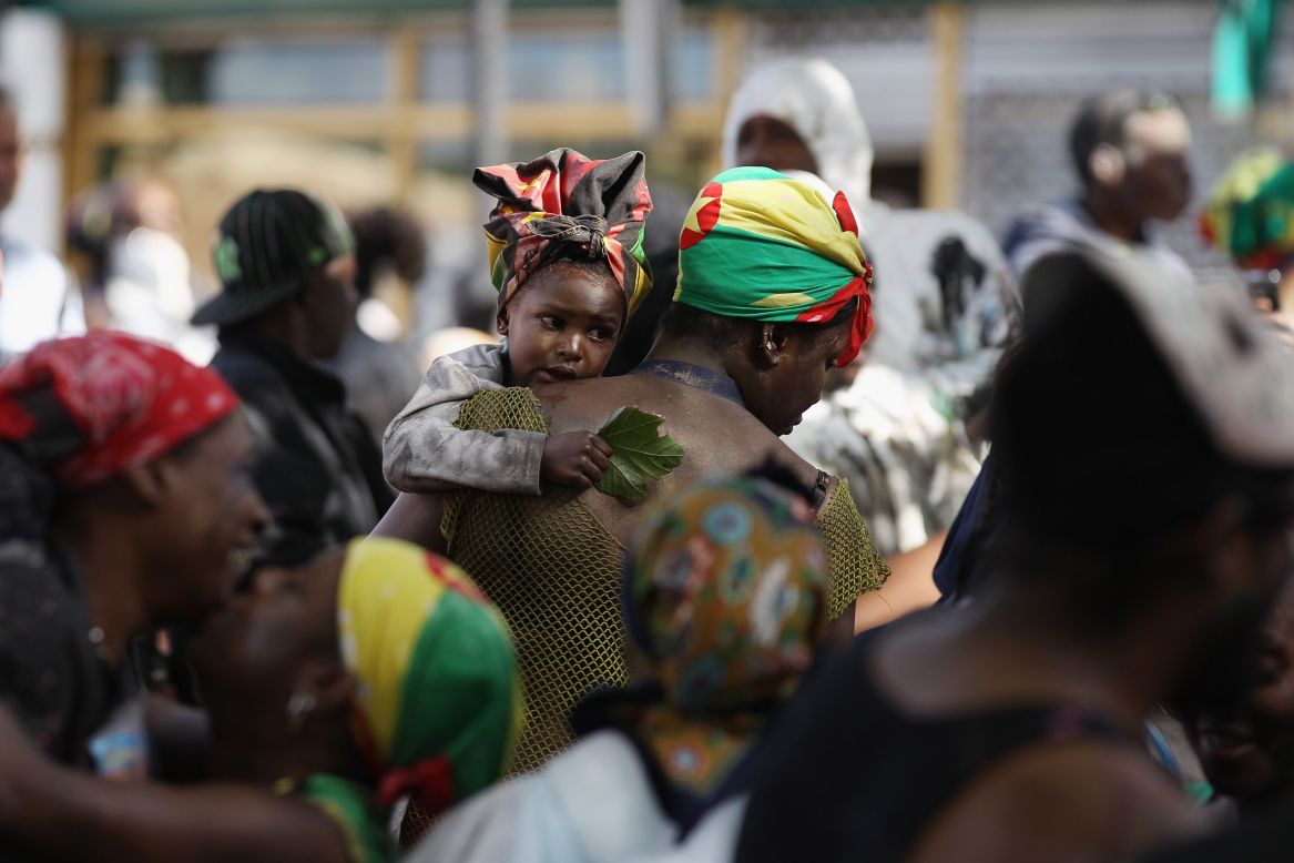 A woman and child move through dancers on family day.