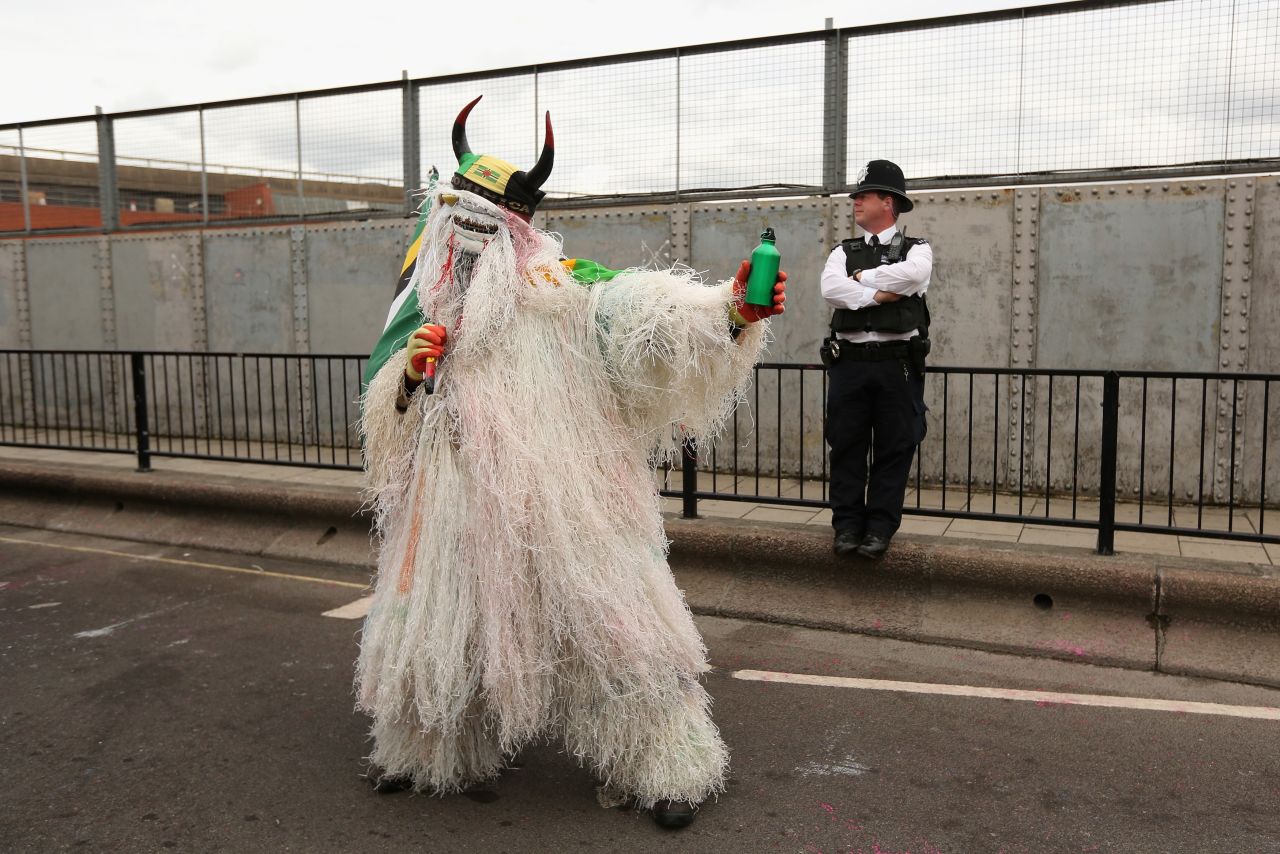 A costumed performer poses Monday in front of a London police officer.