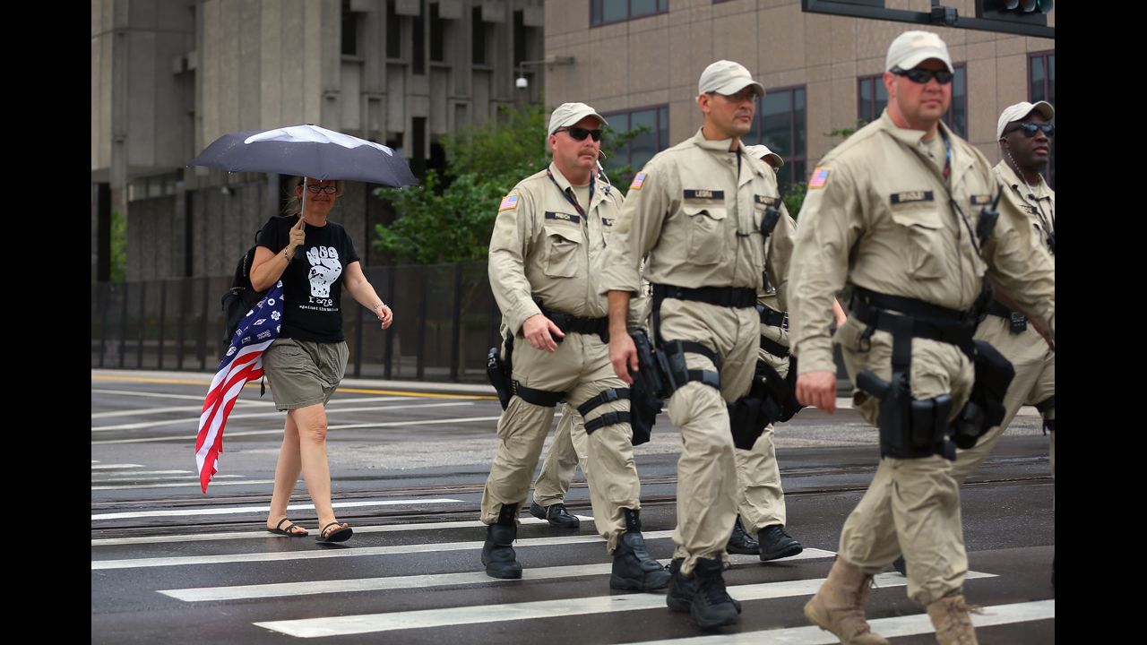 Lynne David walks behind a group of law enforcement officers as they patrol the streets before the convention.