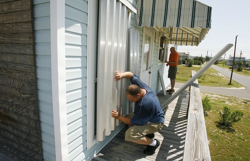 Larry Hoffmeister, left, and Charles Carter place storm shutters on Carter's vacation home on Dauphin Island, Alabama, as they prepare for  Isaac on Sunday.