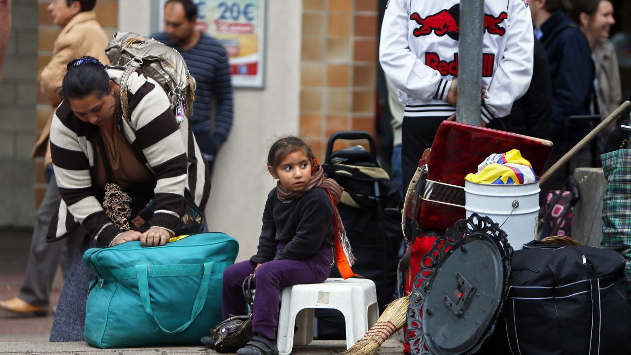 People from the Roma community wait outside their camp in Evry, near Paris,  August 27, 2012.  