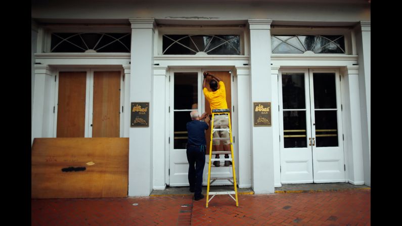 Workers place plywood on the windows of the Royal Sonesta Hotel on Bourbon Street.