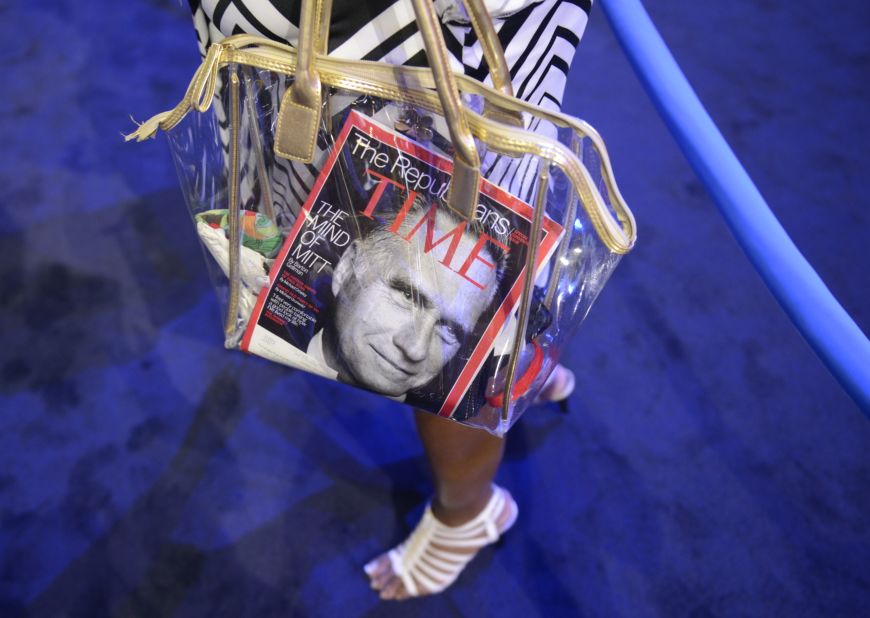 A convention attendee carries a bag with a Time magazine featuring Mitt Romney on the cover.