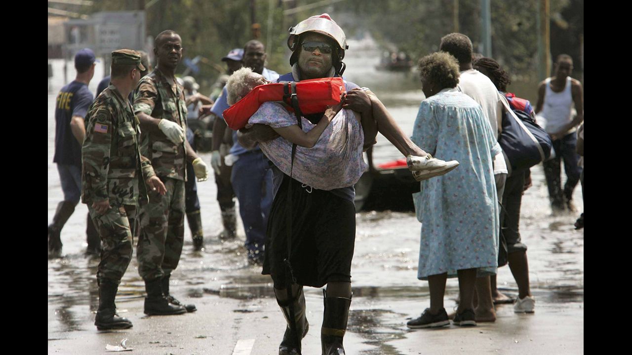  A woman gets carried out of floodwaters after being trapped in her home in Orleans Parish, Louisiana, on August 30, 2005.