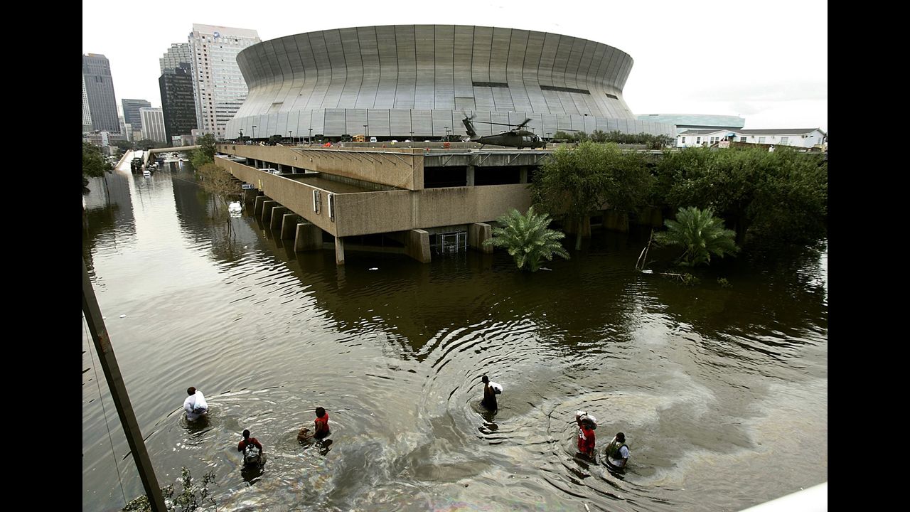 People wade through high water in front of the Superdome in New Orleans on August 30, 2005.