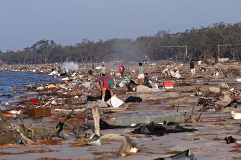 People search for their belongings among debris washed up on the beach in Biloxi on August 30, 2005.
